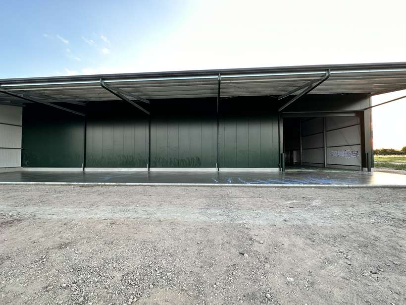 Überdachte Betonfläche an einer fertiggestellten Halle