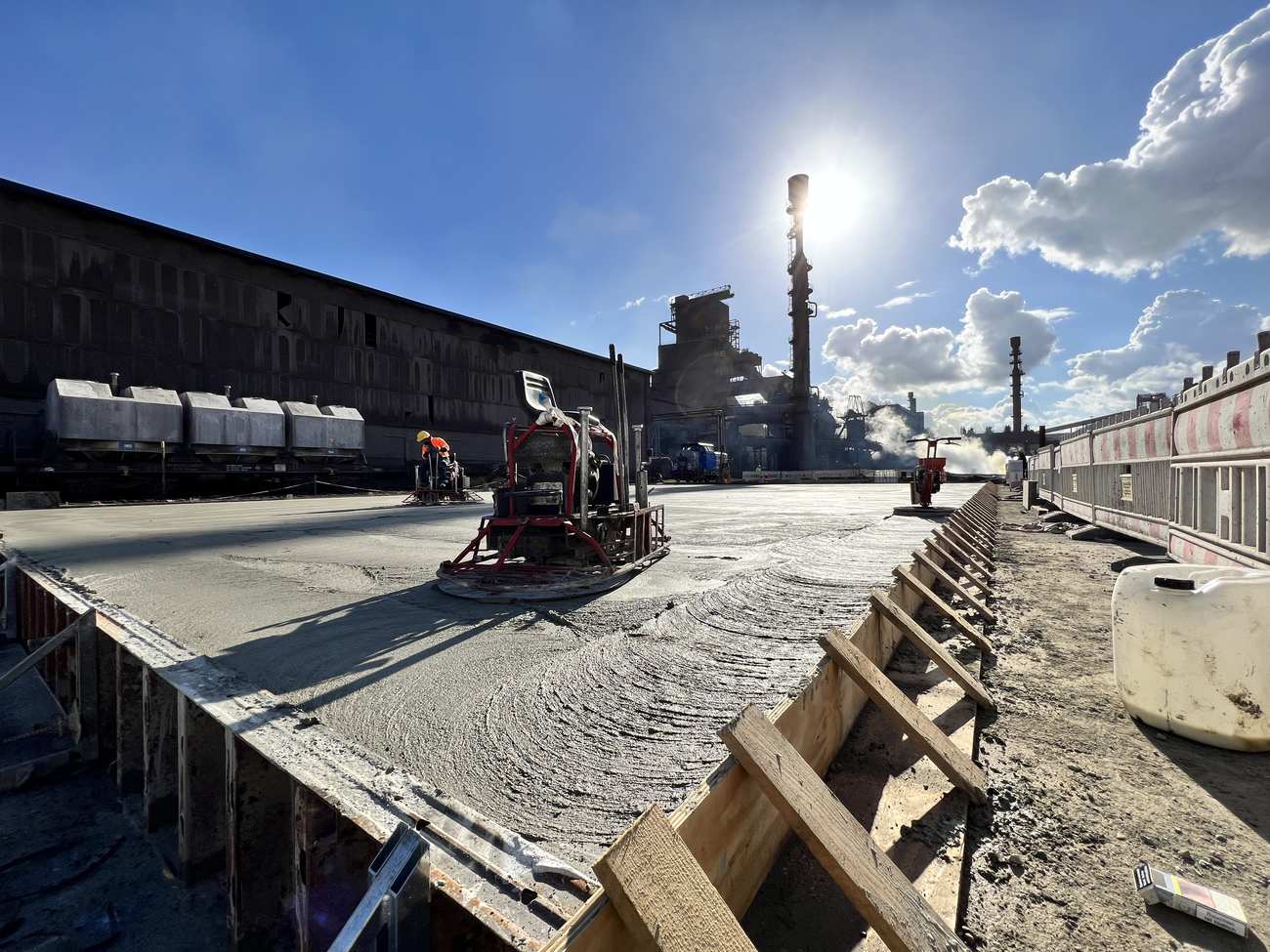 Maschinelles Glätten einer frischen Betonfläche auf einem Industrieareal